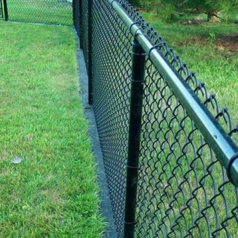 Rubber mow strip under chain link fence. Image courtesy of Bruckman Rubber Co.